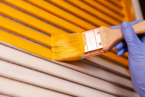 closeup female hand purple rubber glove with paintbrush painting natural wooden door with orange paint colored bright creative design interior how paint wooden surface selected focus 128384 96