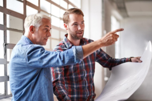that walll needs go shot two male architects holding blueprints inspecting building 590464 18656